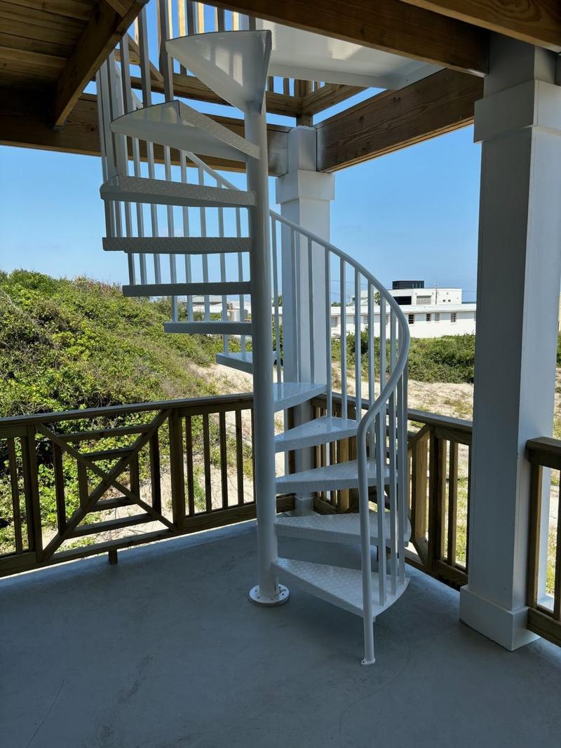 White aluminum spiral staircase on a beach house porch